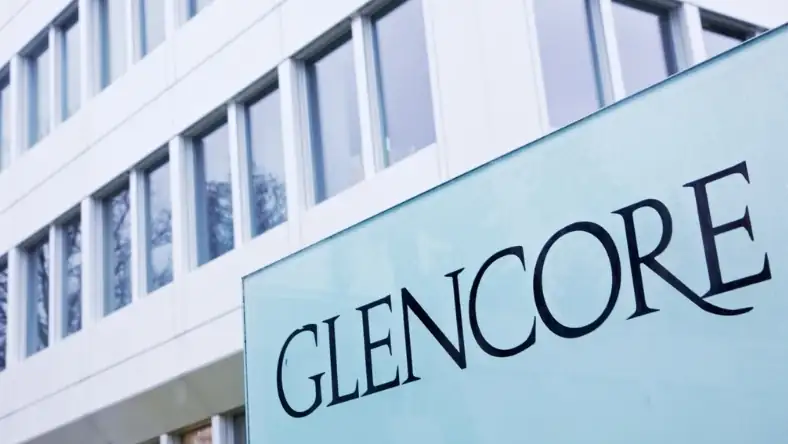 The Glencore company name is displayed on a glass panel outside a modern white office building facade